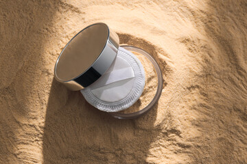 A bottle of light-colored powder on a yellow background.