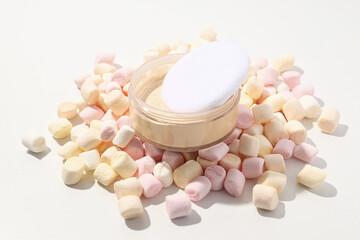 Face powder with marshmallows on a light background.