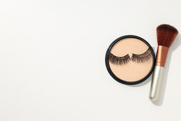 Face powder with a brush, on a light background.