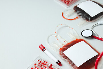 Bags and test tubes with donor blood on white background, space for text