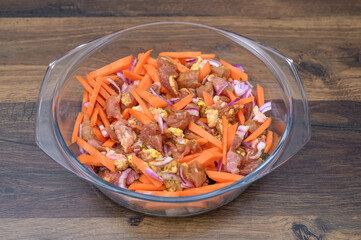 Zdrowy obiad przygotowywany w naczyniu zaroodpornym, pokrojone mięso i kolorowe warzywa