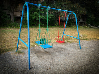 Abandoned metal rusty swings on old children's playground