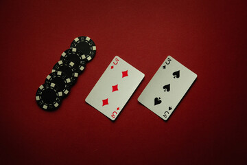 Luck in a poker card game with a winning one pair combination. Playing cards and chips are laid out in a club on a red table