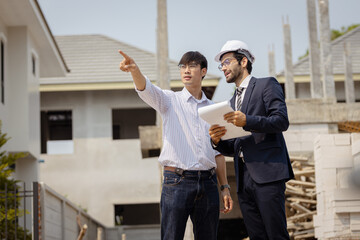 Two Asian engineer working at site of a large building project,Thailand people,Work overtime at...