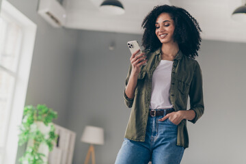Photo of pretty young woman chatting smart phone wear khaki shirt modern interior house indoors