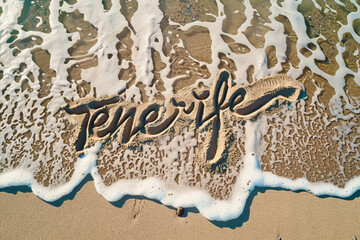 Tenerife, Spain written in the sand on a beach. Spanish tourism and vacation background