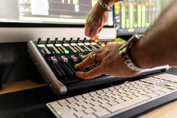 Close-up of sound engineer hands adjusting controls on a sound mixing console - precision and...