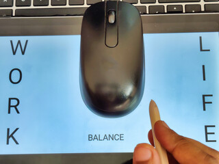 Picture of a person working with a pen in hand. computer mouse on a laptop with the words WORK,...