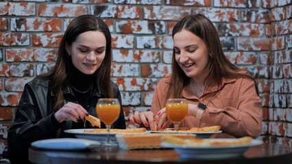 Two cheerful girls in a cafe having dinner.