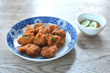 deep fried fish patty on plate with slice cucumber dipping sweet chili sauce 