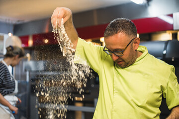 Powdery flour flying into air. chef hands with flour, pizza making masterclass. High quality photo