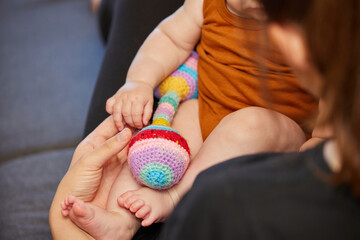 Mom plays with her newborn baby. Close-up