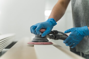 carpenter using sander while working on a piece of wood. High quality photo