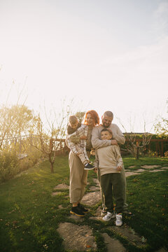 Happy family of father, mother and two sons spending time together outdoors.