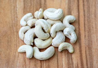 Delicious cashew nuts on wooden background. Cashews are a healthy food rich in protein, healthy fats, fiber, and antioxidants. In the Bengali language, it is called Kaju Badam.