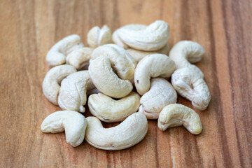 Tasty cashew nuts on wooden background. Cashews are a healthy food rich in protein, healthy fats, fiber, and antioxidants. In the Bengali language, it is called Kaju Badam.