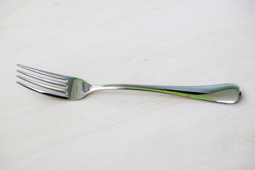 A steel fork spoon on wooden textured background