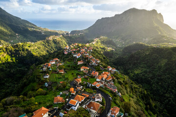 Madeira Island landscape, small village on hills and green lush forest. Aerial drone view. Portugal travel.