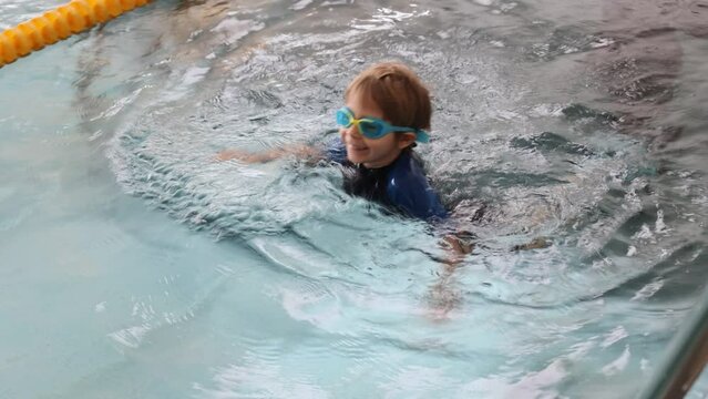 Cute preschool child, sweet boy, swimming in swimming pool