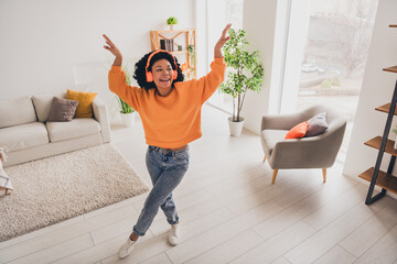 Photo portrait of lovely young lady dance headphones weekend dressed casual orange clothes cozy day light home interior living room - obrazy, fototapety, plakaty