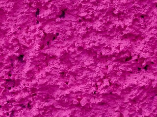 Concrete pink plastered wall fond. Purple grunge wall texture or floor pattern as tile background. Beautiful decorative pink painted stucco fence. Handmade rough winter wallpaper or modern card design
