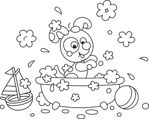 Funny little puppy playing in a bubble bath and splashing with foam in a home bathroom with toys, black and white vector cartoon illustration for a coloring book