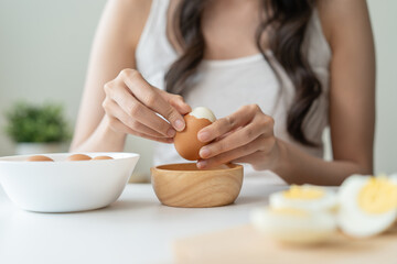 Fototapeta na wymiar woman holding boil egg and pilling off eggshell