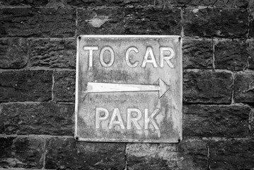 old metal car park sign with arrow