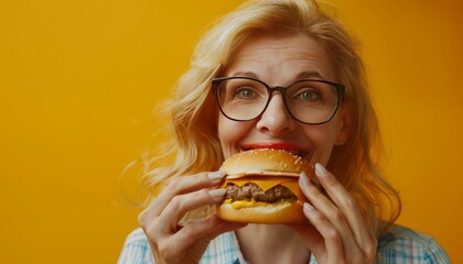 Senior woman savoring burger on pastel backdrop, offering ample space for customized text placement