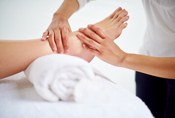 Woman, feet and massage table in spa, therapy and self care for body wellness and resting for...