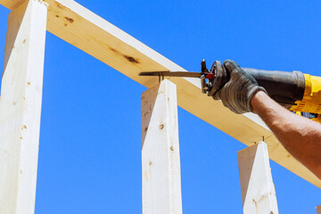 Using reciprocating saw to cut wood beams is construction theme that uses power tools