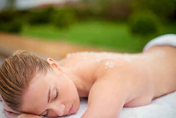 Woman, relax and table in spa with salt, therapy and self care for body wellness and resting for...