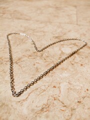 Heart Shaped Necklace on the Floor, Heart Shape Chain in the Sunlight Floor of Marble, Necklace Chain Photography, Isolated Silver Chain Necklace on Marble Floor Jewellery Product Photography