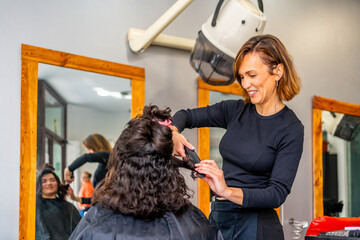 Hairstylist ironing the hair of a client in a salon