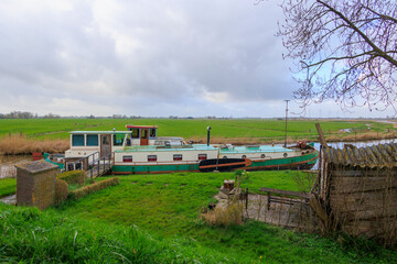 Pleasure craft and houseboats moored on the banks of the North Holland Canal in the Netherlands