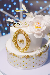 Fototapeta na wymiar Beautiful white two-tiered cake decorated with flowers. 50th Anniversary Cake.