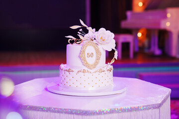 Beautiful white two-tiered cake decorated with flowers. 50th Anniversary Cake.