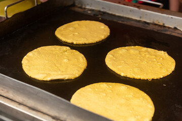 Closed plan of Costa Rican sweet chorreadas on a cooking plate. 