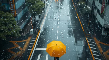 Deurstickers A person is walking down a street with an umbrella in the rain. The umbrella is yellow and the person is wearing a yellow shirt © Дмитрий Симаков
