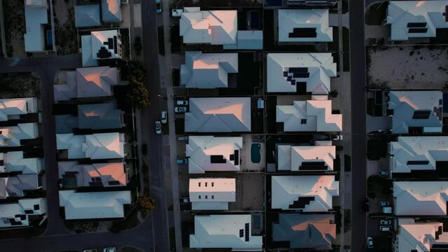 The image shows a collection of houses in a neighborhood from a high angle. The houses are neatly arranged, with streets and sidewalks visible.