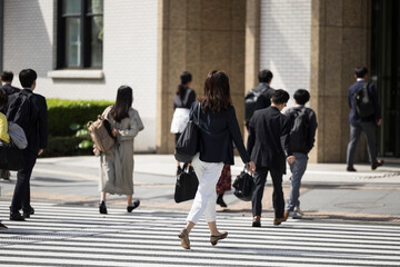 ビジネス街の横断歩道を渡る日本人女性の後ろ姿