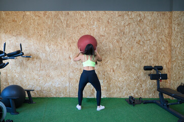 Young and beautiful brunette woman working out in the gym. The woman is doing a rehabilitation...