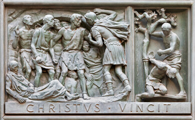 MILAN, ITALY - SEPTEMBER 16, 2024: The relief of Martyrdom of St. Gervasius on the bronze gate of Cathedral - Duomo by Arrigo Minerbi (1937 - 1948)