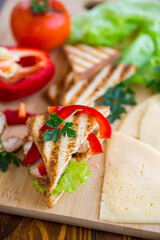 fried toast with chicken, salad, greens on a wooden table