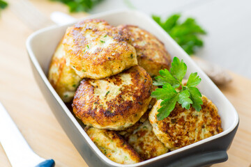 fried meat cutlets in a ceramic form on a wooden table