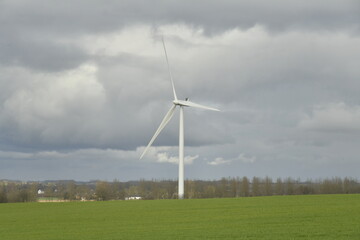 Éolienne se dressant sous un ciel gris dans un paysage rural à Ghislenghien (Ath)