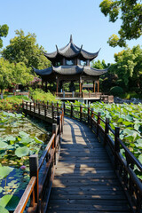 Fototapeta premium A wooden bridge in a lotus pond, with a Chinese pavilion in the background 