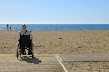 hombre mayor en silla de ruedas discapacitado minusválido  en una playa accesibilidad 4M0A8540-as24
