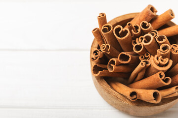 Cinnamon sticks on a textured wooden background. Cinnamon roll. Spicy spice for baking, desserts and drinks. Fragrant ground cinnamon. cinnamon powder Close-up. Place for text. copy space