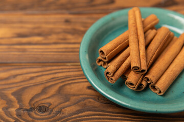 Cinnamon sticks on a textured wooden background. Cinnamon roll. Spicy spice for baking, desserts and drinks. Fragrant ground cinnamon. cinnamon powder Close-up. Place for text. copy space